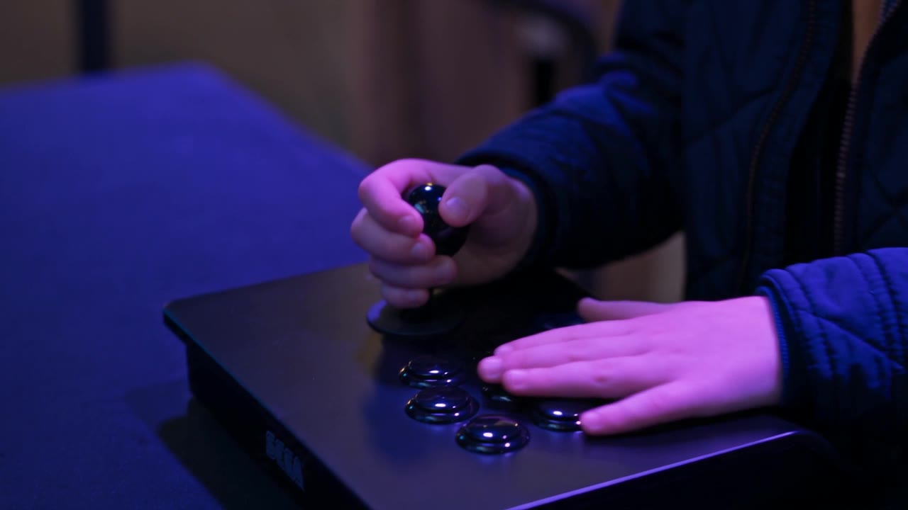 The boy's hands on the stage's play panel, a stick and two buttons